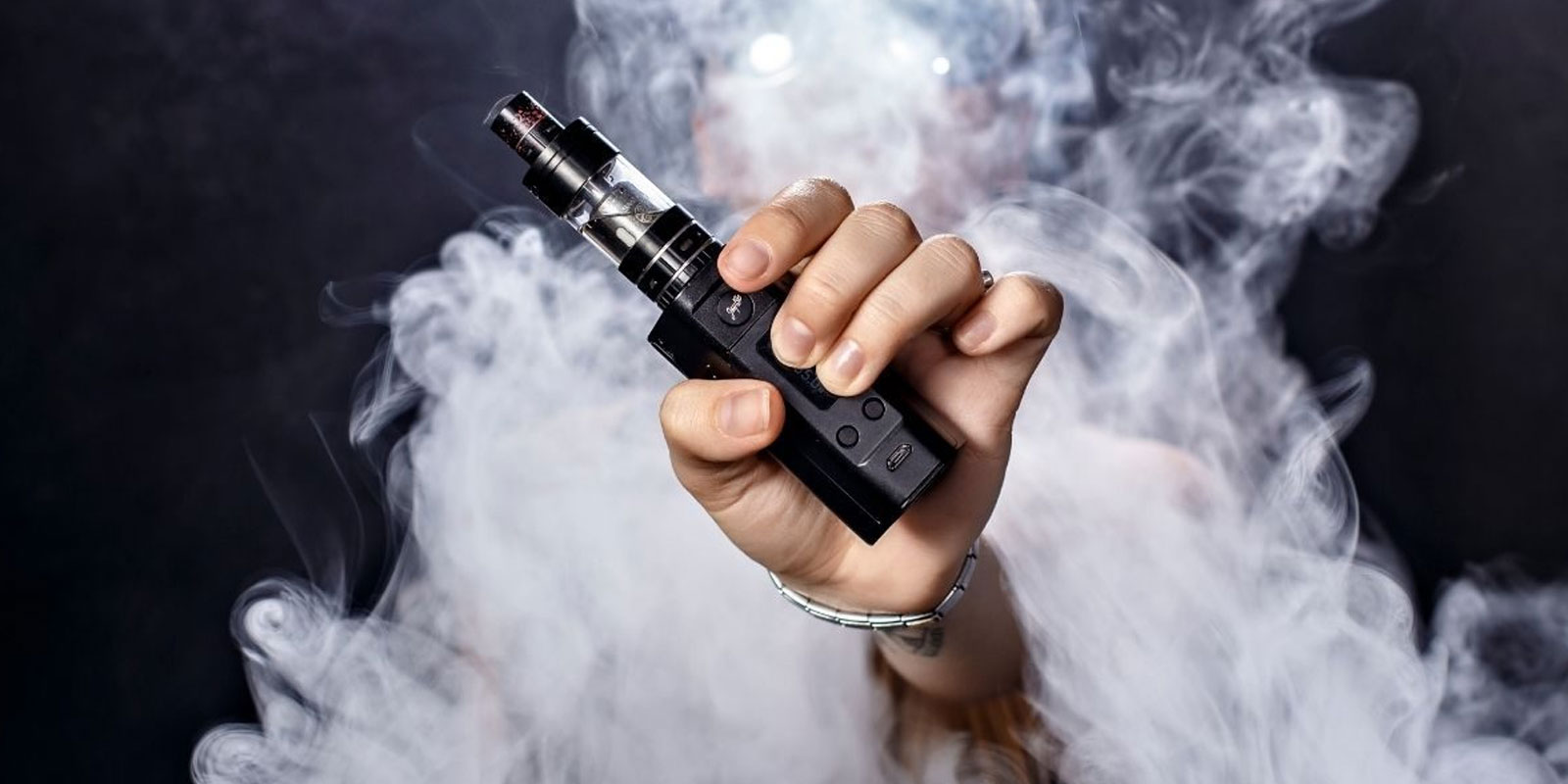 A person holding an electronic cigarette in their hand.