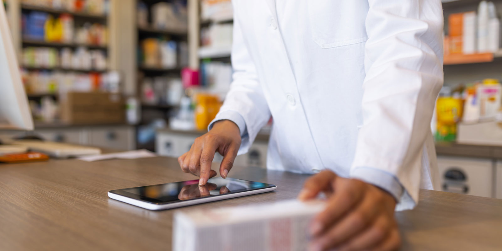 A person in white lab coat using tablet computer.